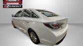 Rear three-quarter view of a white sedan with Easton Motors EZ Credit logo in the corner and 'APPLY, ARRIVE & DRIVE!' text at the bottom.