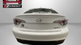 Rear view of a white Hyundai Sonata Hybrid in a studio, with Easton Motors EZCredit logo at upper left and a red 'APPLY, ARRIVE & DRIVE!' banner at the bottom.