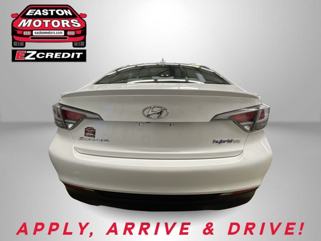 Rear view of a white Hyundai Sonata Hybrid in a studio, with Easton Motors EZCredit logo at upper left and a red 'APPLY, ARRIVE & DRIVE!' banner at the bottom.