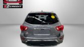 Rear view of a gray Nissan Pathfinder with EZCredit logo on left and a yellow smiley sticker on rear window, showroom backdrop.