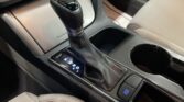 Gear lever for an automatic transmission in a car, surrounded by leather and a nearby drive mode button.