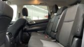 Rear passenger seats in a dark-gray car with three headrests and visible seat belts against gray fabric upholstery.