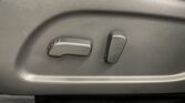 Close-up of car seat adjustment controls on the side of the seat: a horizontal rocker switch and a vertical switch for seat position.