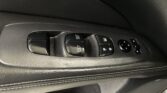Driver-side door panel with power window and lock controls in black plastic trim.
