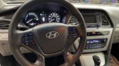 Driver's view of a Hyundai interior: steering wheel, digital instrument cluster, center console, and gear shifter.