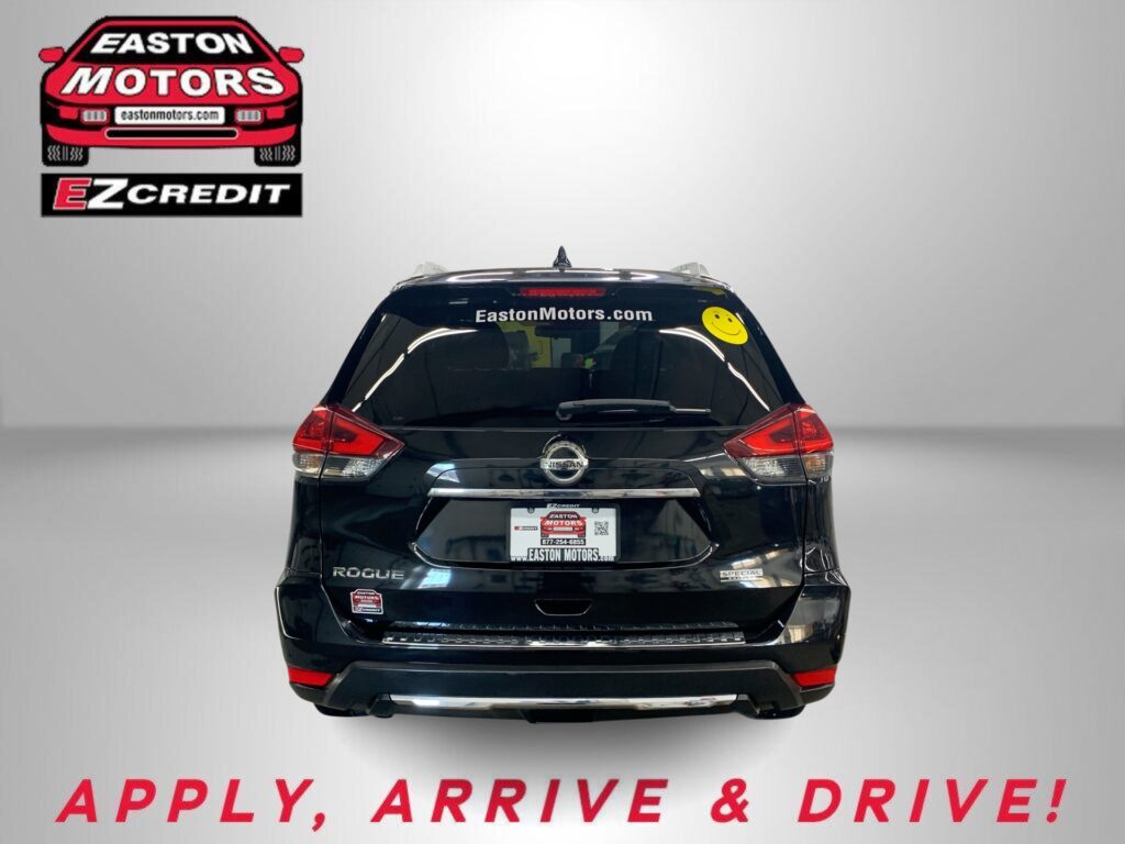 Black Nissan Rogue rear with Easton Motors branding on the rear window and a yellow smiley sticker; banner at bottom reads 'APPLY, ARRIVE & DRIVE!'
