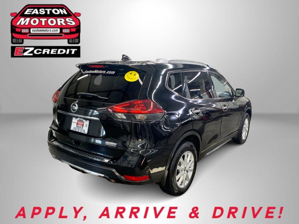 Black Nissan SUV shown from rear-side in a showroom, with Easton Motors branding on the wall and the slogan 'APPLY, ARRIVE & DRIVE!' in red text below.