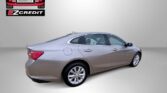 Beige four-door sedan from rear three-quarter view; Easton Motors EZ Credit logo top-left and the slogan 'APPLY, ARRIVE & DRIVE!' bottom.