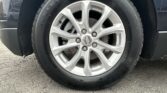 Close-up of a car wheel and tire with a Chevrolet emblem on the hubcap, mounted on a paved surface.