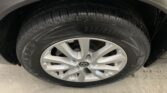 Car tire and alloy wheel visible in a vehicle’s wheel well; tire reads 225/65R17 and has a Nissan center cap with a silver rim and some dirt around the tread.