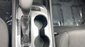 Center console with gear shifter, two cup holders, and electronic parking brake (P button) visible. Gear sequence P R N D L shown on the shifter.