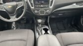 Front interior of a Chevrolet car showing steering wheel, center console, and dashboard with infotainment screen