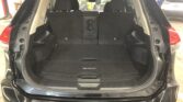 Open tailgate of a black Nissan Rogue showing the cargo area with folded third-row seats and a black floor mat labeled 'ROGUE'