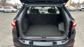 Open rear hatch of a black SUV showing a large cargo area with folded third-row seats inside