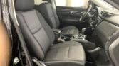 Interior of a car showing front seats, center console, and steering wheel; black fabric seats with light stitching and a clean modern dashboard visible from the driver's side door