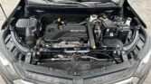 Front view of a car engine bay with an ECOTEC engine cover, battery, and fluid reservoirs visible.