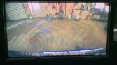 Rearview camera feed with parking guide lines (green, yellow, red) showing a workshop area behind the vehicle; caption reads, 'Check surroundings for safety.'
