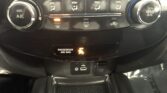 Car climate control panel: left A/C dial, right MAX A/C dial, center buttons for airflow and defog; front defrost lit; rear defog and recirc buttons nearby.