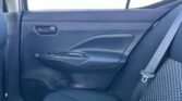 Rear passenger door interior: dark fabric panel, door handle, window, and a patterned seat with a visible shoulder seat belt crossing the seat.