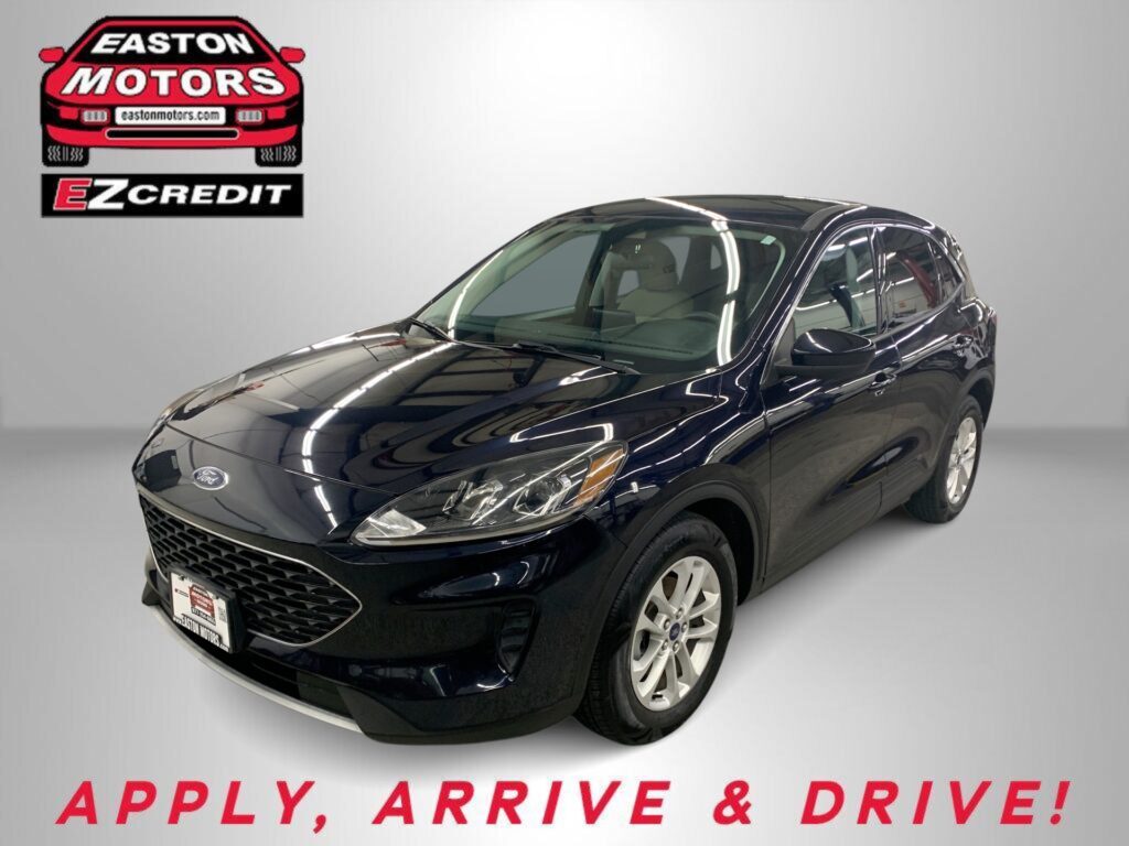 Black Ford SUV in a showroom with an Easton Motors EZCredit logo on the wall and the slogan 'Apply, Arrive & Drive' visible.