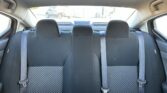 Rear car seats with three headrests and three seat belts in a compact car interior of a sedan/SUV.