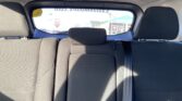 Rear car seat interior with fabric upholstery, headrests, and a visible seatbelt across the right side of the image