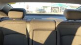 Backseat of a car with two headrests, view of a street scene through the rear window.