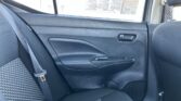 Rear passenger area of a car interior: gray patterned back seat with a seatbelt across it, door panel and handle, window showing a newspaper taped outside.