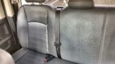 Rear car seat with black leather upholstery and three-point seat belts, headrests visible at the top