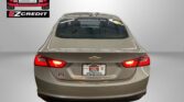 Rear view of a beige Chevrolet sedan in a showroom, with an Easton Motors logo on the left and the slogan 'APPLY, ARRIVE & DRIVE!' below.