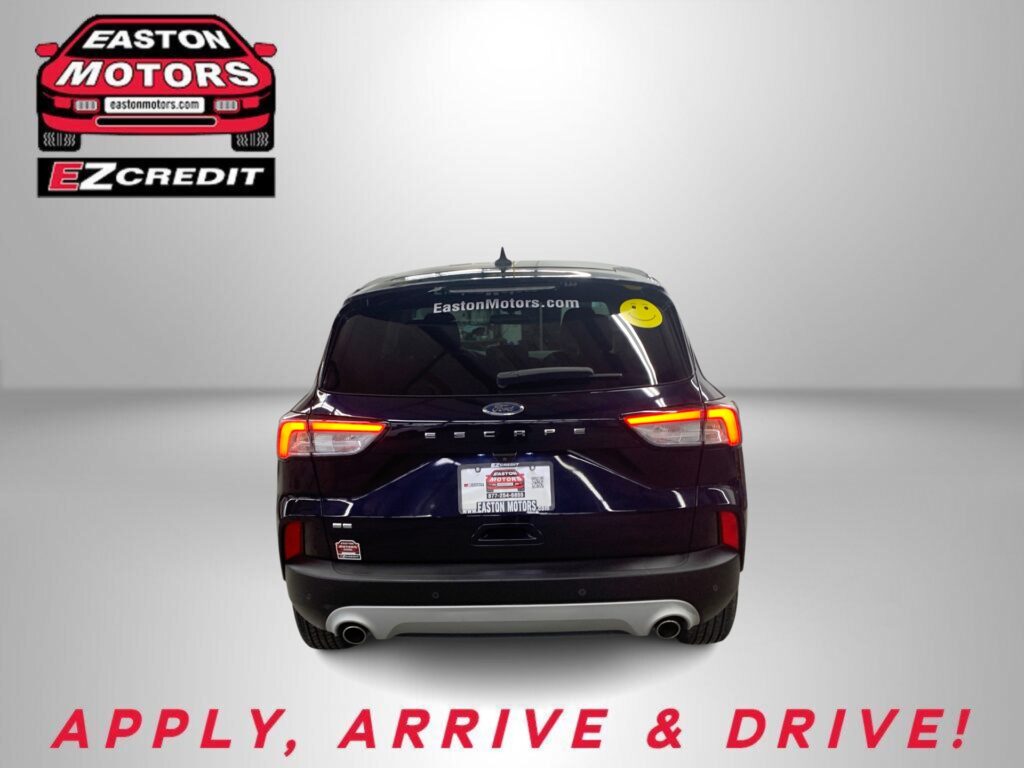 Rear view of a dark SUV with Easton Motors branding on the back window and a yellow smiley sticker; ad text below reads 'APPLY, ARRIVE & DRIVE!'