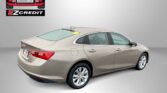 Beige Chevy sedan shown from rear-side with Easton Motors EZ Credit logo in the upper left and the slogan 'APPLY, ARRIVE & DRIVE!' at the bottom.