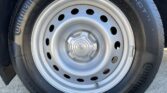 Close-up of a steel car wheel with a Ford center cap and a Continental tire around it.