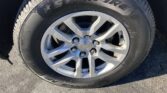 Close-up of a tire mounted on a silver multi-spoke alloy wheel with a Chevrolet center cap visible on asphalt pavement.