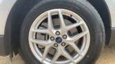 Close-up of a car wheel showing a silver alloy rim with Ford center cap and black tire.