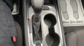 Center console with gear shifter, two cup holders, and an electronic parking brake button in a car interior.