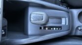 Close-up of a car's center console showing a textured parking brake lever and a control panel with window and lock icons.