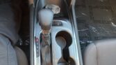 Center console in a Chevrolet, showing gear lever (P R N D L) and two cup holders with a lit parking brake indicator nearby.