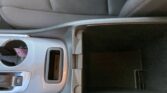 Close-up of a car's center console: cup holder, gear selector area, and a small storage pocket.