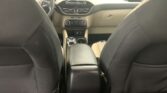 View from the back seat of a car interior, showing the front seats, center console, and dashboard with a touchscreen display above the climate controls.