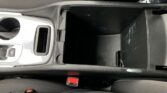 Open center console in a car showing a large storage bin and a cup holder beside it.