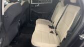 Rear car seats with beige quilted upholstery and black door panel, view from open rear door.