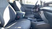 Interior of a modern car cabin from the passenger side, showing front seats, center console, and steering wheel with dashboard controls visible.