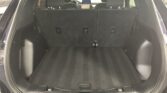 Open SUV trunk with rear seats upright, showing a spacious dark cargo area lined with carpeted floor.