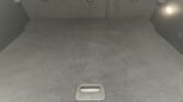 Empty car cargo area with rear seats upright and a small interior light on the right side.