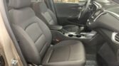 Front seats and dashboard of a car interior, steering wheel on the left, center console with two cupholders and gear shifter visible.