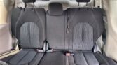 Rear car seats: three black fabric seats with white stitching, headrests, and visible seat belts/buckles.
