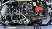 Car engine bay with black Nissan intake cover and red battery visible on the right side