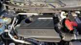 Under-hood view of a Nissan engine bay with a prominent VC-Turbo cover and engine components visible behind the front grille of the car's bay area.