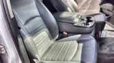 Front seats of a gray leather car interior with a center console and cup holders visible at the center.